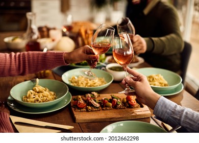 Close-up Of Friends Celebrating And Tasting With Wine While Eating Lunch At Home. 