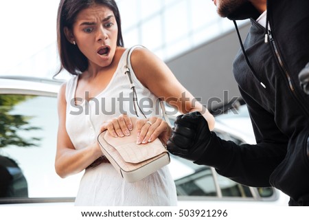 Closeup of frightened shocked young woman being robbed by thief outdoors Foto stock © 