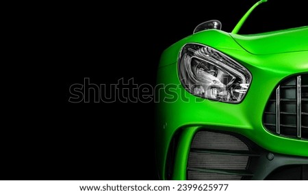 Close-up front eyesight headlight with LED xenon light of green modern car on black colour background and copy space