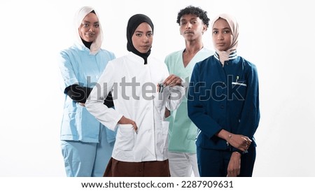 Closeup front view of group of mixed age doctors and nurses standing side by side and looking at the camera. Young Middle Eastern female in a team with African American male doctor. 