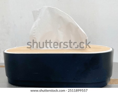 Close-up front view of a tissue box, showing the textured paper and the opening for dispensing tissues.