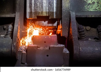 Close-up Frontal View Of Hot Steel Forging Process With Big Mechanical Hammer Machine