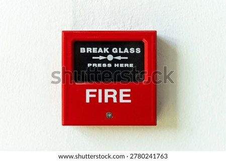 A close-up, front-facing shot of a red fire alarm manual call point with the text 