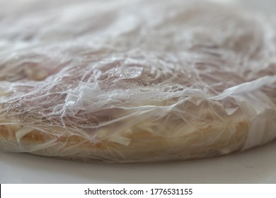 Closeup Of Frozen Pizza Including Packing On A White Table