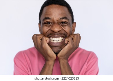 Closeup of frustrated African American man clenching teeth. Nervous young male model with short dark hair in pink T-shirt looking at camera, leaning on hands and frowning. Anxiety concept - Shutterstock ID 2224023813