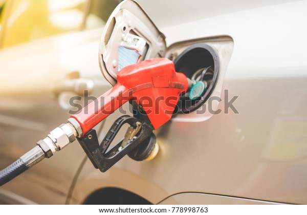 Close-up fuel\
nozzle. Fill up fuel at gas\
station.