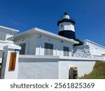 Closeup of Fugui Cape Lighthouse (same name written on wooden sign at the door), Shimen, Taiwan - 26 August 2024 (sunny blue sky)