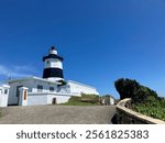 Closeup of Fugui Cape Lighthouse (same name written on wooden sign at the door), Shimen, Taiwan - 26 August 2024 (sunny blue sky)