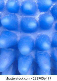 Close-up full frame background texture of vibrant blue tactile bubble surface with rounded spherical bumps, creating a modern futuristic geometric pattern and sensory design element.