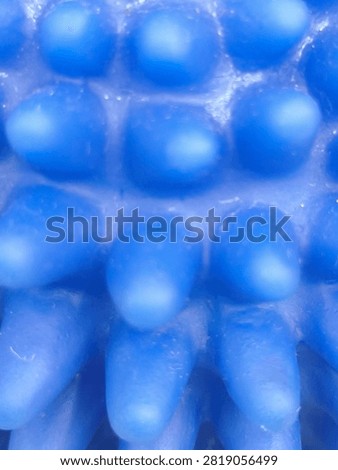 Close-up full frame background texture of vibrant blue tactile bubble surface with rounded spherical bumps, creating a modern futuristic geometric pattern and sensory design element.