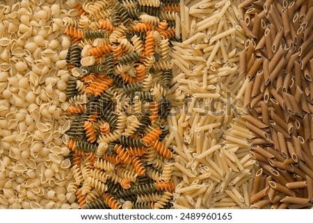 Close-up full frame color background photo of various types of uncooked pasta noodles.