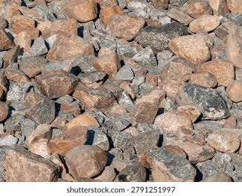 Close-up full frame texture of various rough gray and brown rocks and cobblestones