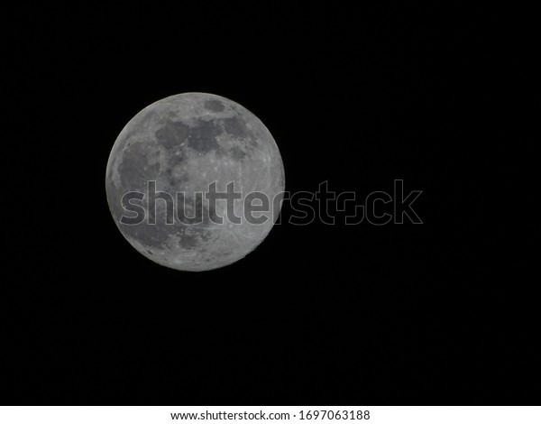 Closeup of Full Moon on a clear black night\
sky. Background.