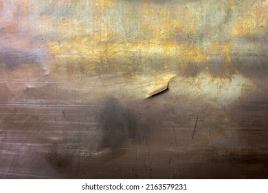 closeup full-frame background and texture of yellow brass sheet with dent and oxidation stains