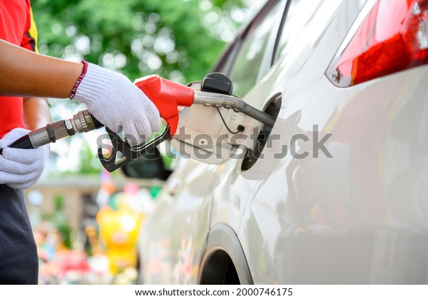 Close-up of a gas station worker working with a
gasoline injector pump. to refuel Petrol pump - refueling Car
refueling station.