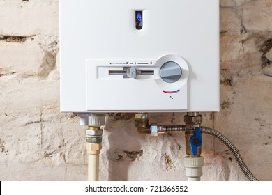 Closeup Of Gas Water Heater On A Brick Wall. Gas Boiler In Boiler Room For Hot Water