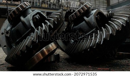 Close-up, gears, differentials, cogs, tools, old black dirty parts for cars, trucks, on the factory floor.