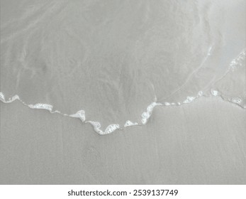 Close-up of gentle waves on a sandy beach. Serene view on the beach. Parangtritis beach. Yogyakarta - Powered by Shutterstock