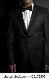 Close-up of gentleman wearing black  bowtie on black
