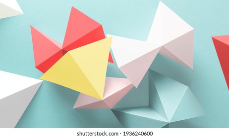 Close-up of geometric shapes made paper, isolated on light blue
