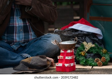 Close-up of gift boxes and donation bowls of homeless beggar, Christmas celebration time