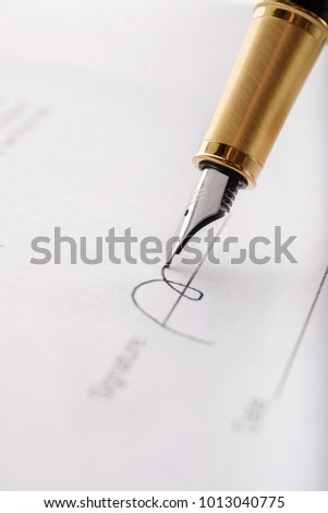 Close-up of gilded fountain pen signing contract, document. Vertical image.