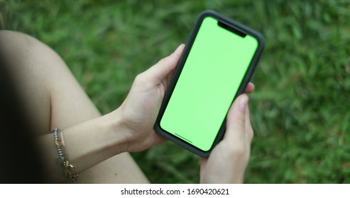 
Closeup Of Girl Hands Holding Smartphone With Greenscreen