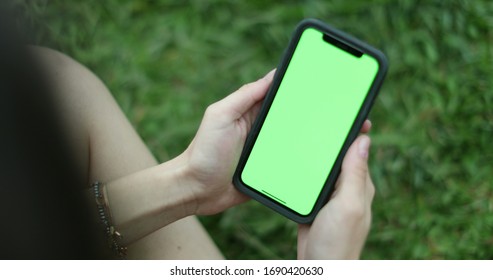 
Closeup Of Girl Hands Holding Smartphone With Greenscreen