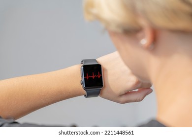 Close-up Of A Girl Looking At The Dial Of A Smart Watch That Shows An Increased Heart Rate. Rapid Heartbeat. Anxiety Disorder.