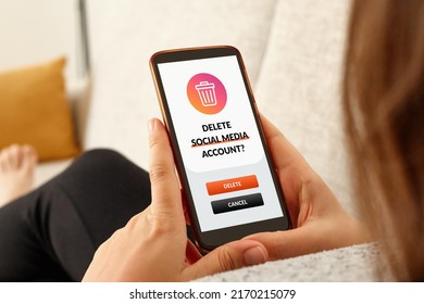 Close-up Of Girl On A Sofa With Smartphone Deleting Social Media Account.
