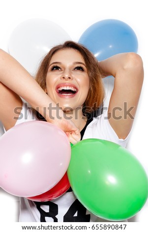 Close-up of a girl smiling widely and playing with colorful latex balloons. Studio shoot on white background not isolated