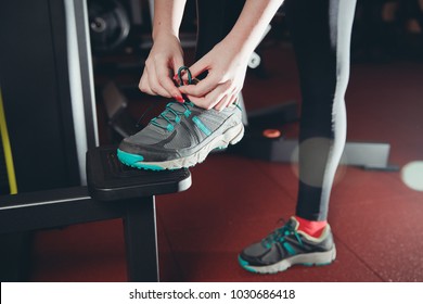 Close-up Of Girl Tying Shoelaces On Sports Shoes In Gym.