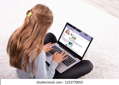 Close-up Of A Girl Using Social Networking Site On Laptop At Home - Powered by Shutterstock