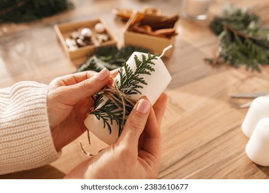 Close-up of a girl's hands decorating candles with New Year or Christmas decor. Woman creates holiday decorations, candles for home. - Powered by Shutterstock