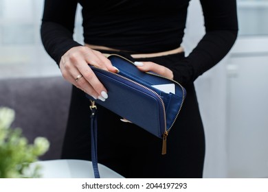 Close-up of a girl's hands with an open purse in her hands. An empty wallet is a woman with no money in her wallet. Wallet made of genuine blue leather - Shutterstock ID 2044197293
