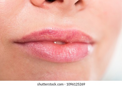 Close-up of girl's pink lips with clean lipstick make up. macro transparent lipgloss make-up