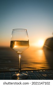 Close-up Of Glass With Champagne Wine. Sunset Sky On Background.