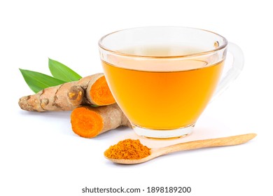 Closeup Glass Cup Of Hot Turmeric Tea With Tumeric Root And Powder In Wooden Spoon Isolated On White Background . 