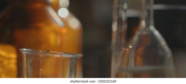 Close-up Of Glass Flasks, Tubes On The Table. Vintage Cinematic Concept. Workshop. Depth Of Field, Soft Focus