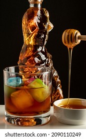 close-up glass glass high alcohol whiskey with colored ice blocks and bottle body carafe drink concept