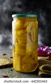 Closeup Of A Glass Jar With Cooked Cardoon On A Rustic Wooden Table