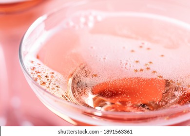 Closeup Of Glass With Sparkling Rose Wine Decorated Gold Star Confetti, Celebration Party On Pink Background