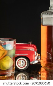 close-up glass glass of spirit whiskey with colored ice blocks and bottle classic car drink concept