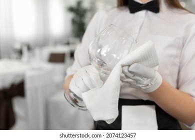 Close-up of a glass and a towel in the hands of a waiter. Preparation, table setting. - Powered by Shutterstock