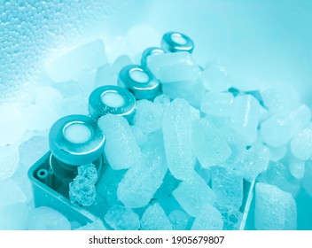 Closeup Of Glass Vials With Crimp Caps And Hoarfrost On Them Placed On Dry Ice Prepared For Medical Transport. The Vials Are Obscured By A Haze Of Sublimating Dry Ice. Selected Focus.