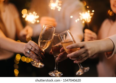 Close-up of glasses of clinking Champagne with Bengali lights. Celebration concept - Powered by Shutterstock