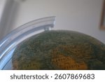 Close-up of a globe captured in a study room in New York City. The globe highlights intricate geographical features and countries, reflecting the world