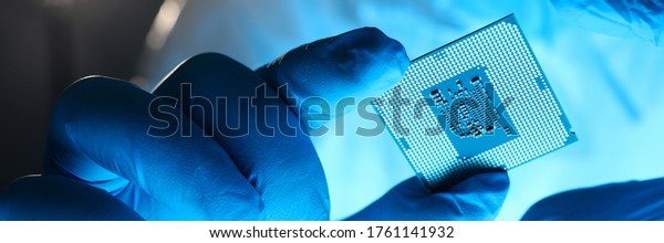 Close-up\
gloved hands holding detail microchip. Man in special uniform shows\
microprocessor chip. Production technology hitech. Repair\
microprocessor electronics electrical\
equipment.