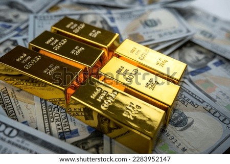 closeup gold bar lying on 100 dollar bills. Gold bullion and money concept