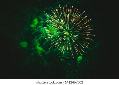 Close-up Gold And Green Festive Fireworks On A Black Background. Abstract Holiday Background